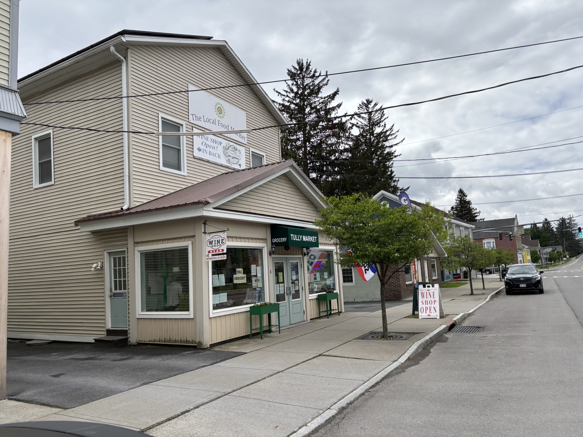 Storefronts, trees and sidewalk along a street in the Village of Tully